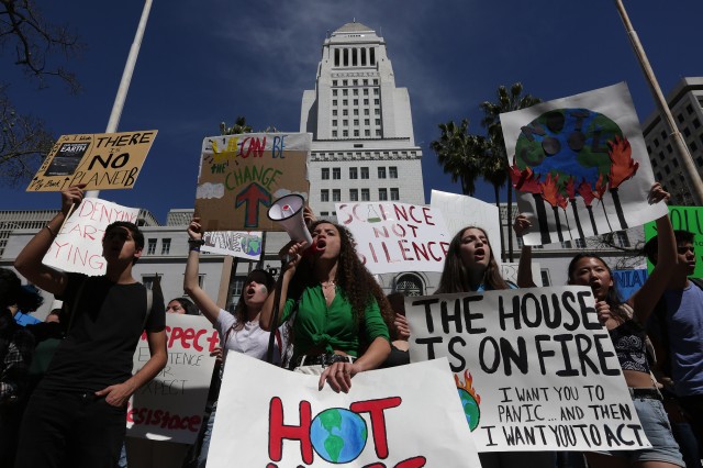 People holding signs and speaking into a megaphone