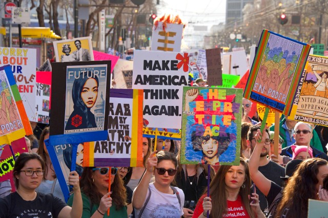 women holding colorful protest signs