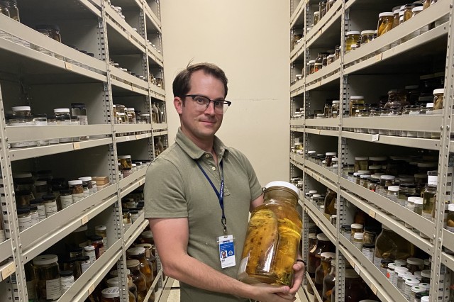 Bill holding larger jar