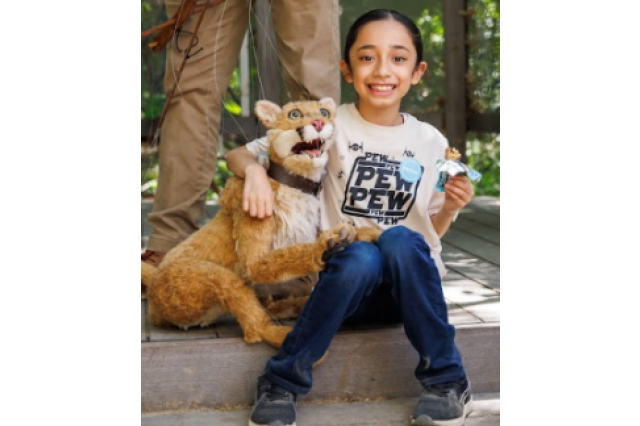 Child sitting on floor with p-22 puppet 