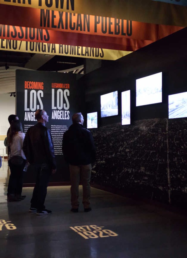 Entrance to Becoming Los Angeles Exhibition filled with historic images and colorful banners