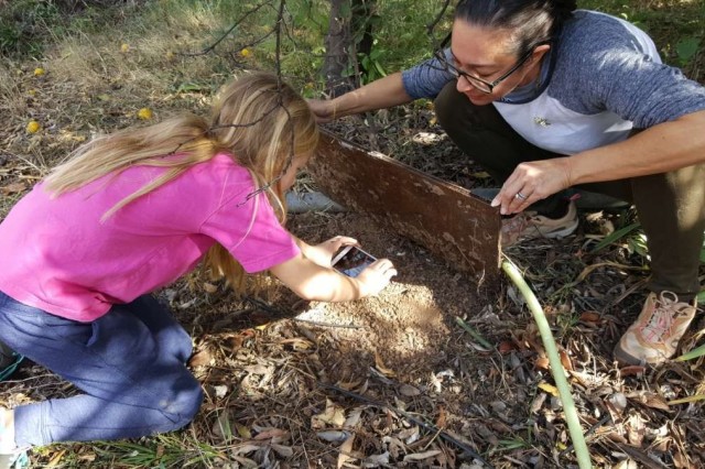 Charlotte and her mom Amelia check underneath a cover board