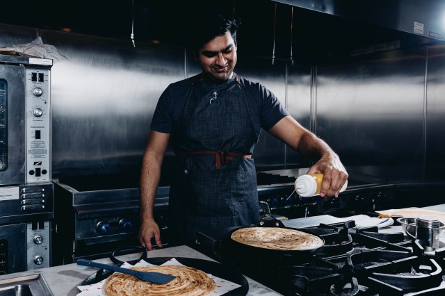 man at stove making flatbread