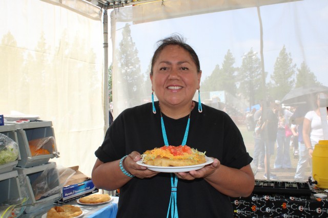 Woman in black shirt holding plate of food 