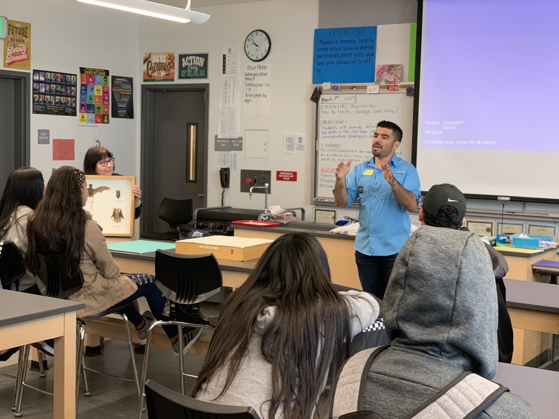 Miguel Ordeñana visits a classroom at Jordan High School as teacher, Yolanda Grisolia holds specimens from the Natural History Museum