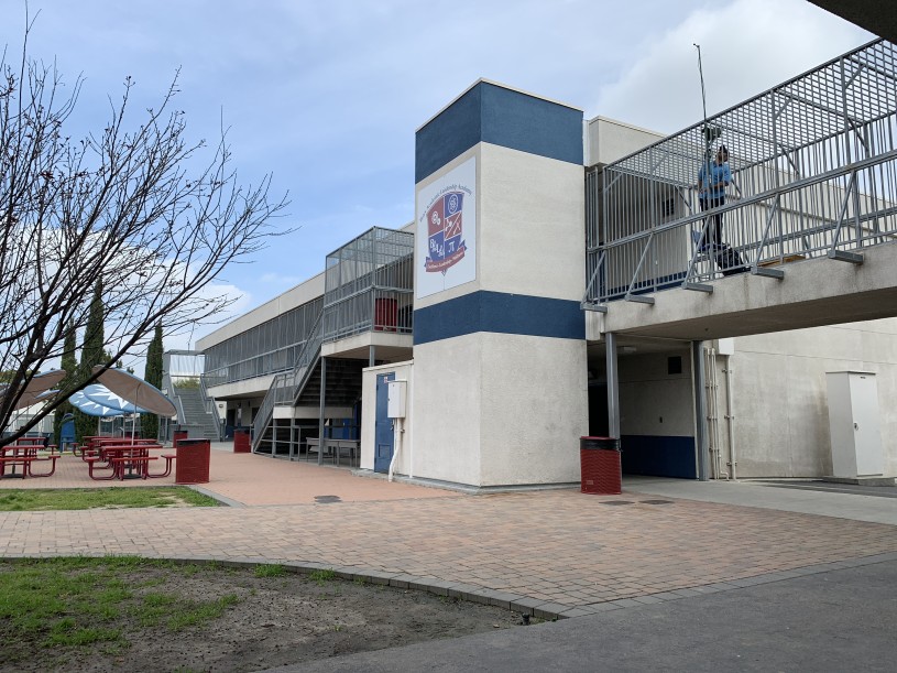 Miguel Ordeñana stands on a balcony checking a bat detector at BALA school.