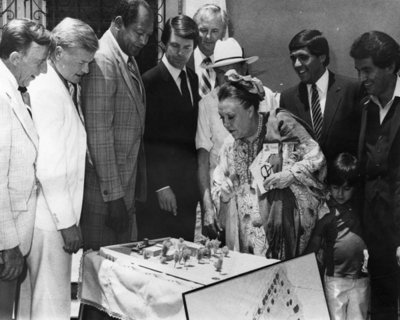 Margo and a group of people standing over a model 