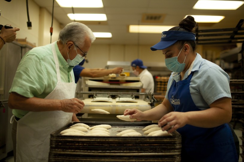 Baker and assistant placing bolillos 