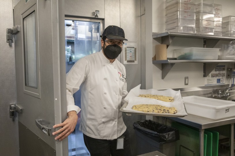 Chef walking through door with bread 