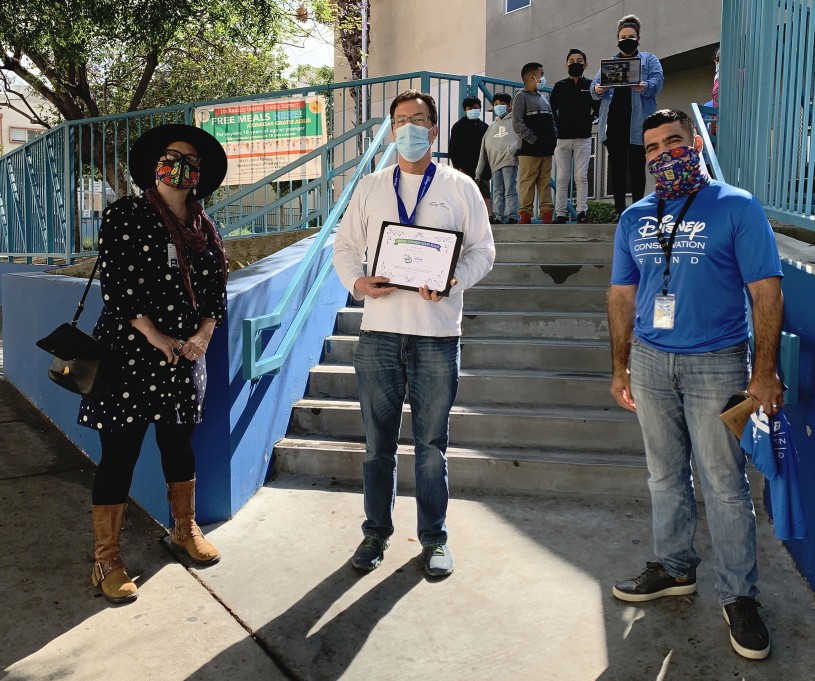 Brad Rumble presented with an award by Lila Higgins and Miguel Ordenana