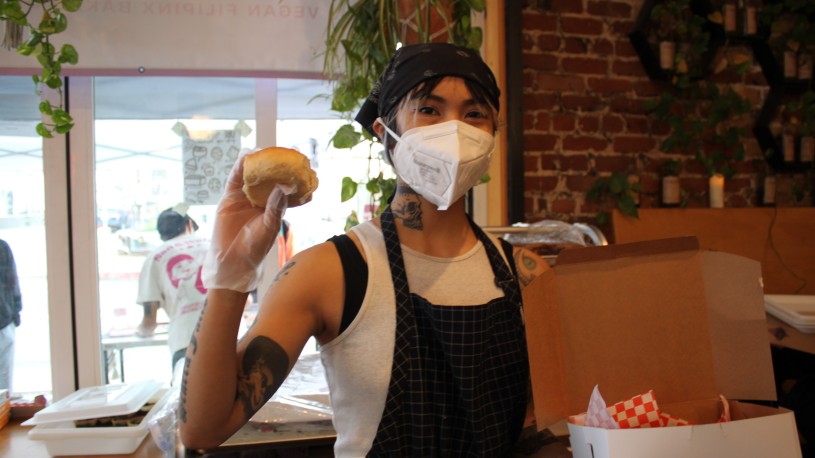 Women with mask holding bread 