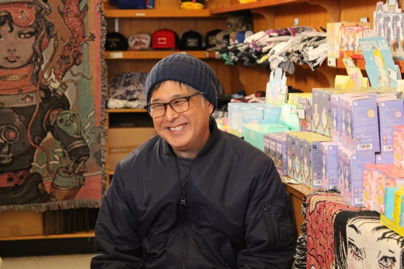 Man in black seated in gift store 