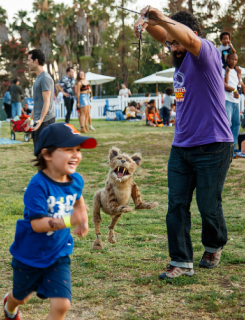 Man holding marionette child running along side it 