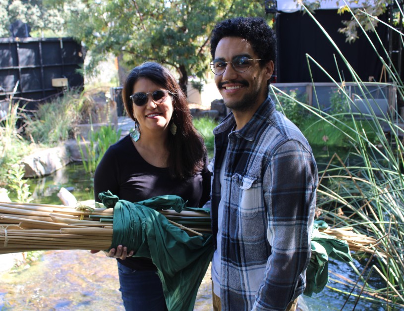 two people stand by a pond 