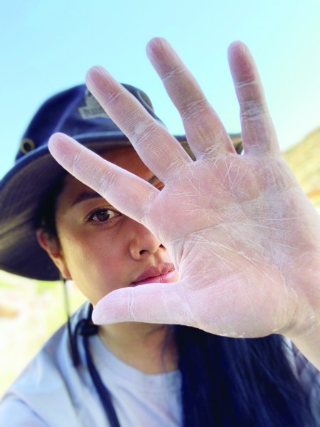 Close up of diana kou's dusty hand with her face out of focus 